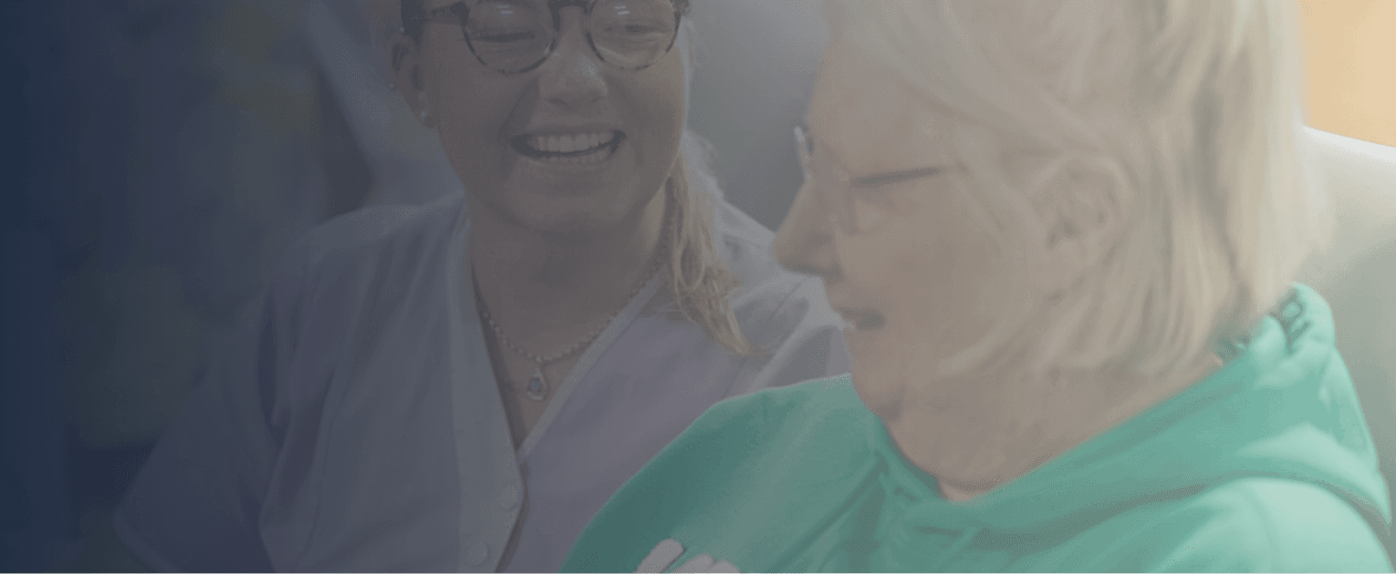 Nurse supporting an elderly woman at home